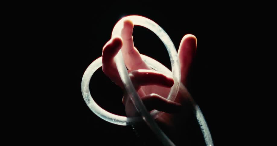 Liquid moves through a tube wound through a persons fingers