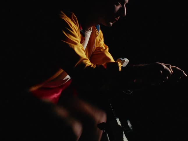A young man exercises on an indoor spin bike