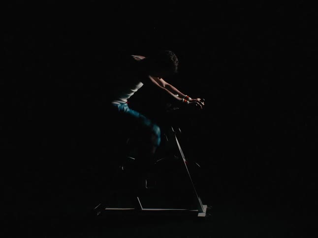 A man in a room exercising on a stationary bike