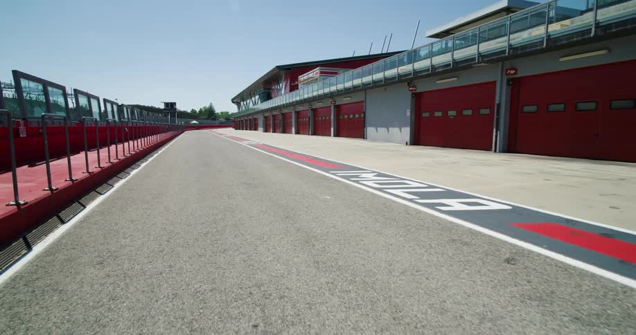 The sidewalk and garage doors are painted bright red at a race track
