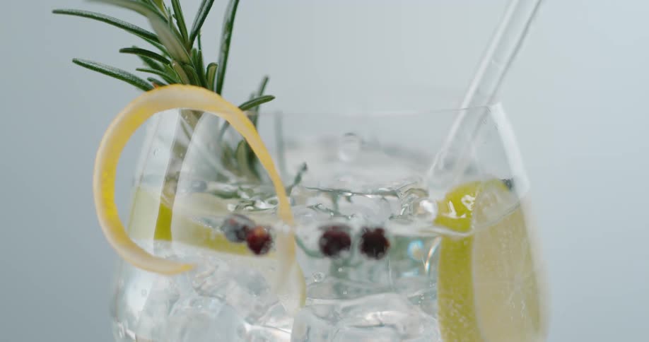 An ice cube falls in to a cocktail