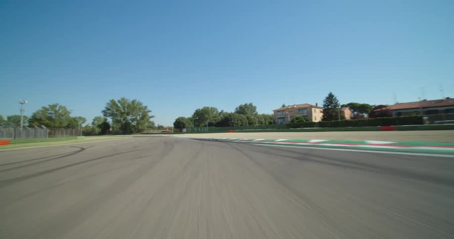 A car driving fast down a road on a sunny summer day