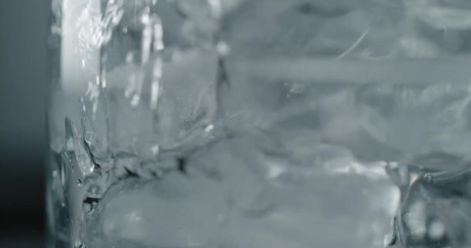 Water being poured into a glass of ice