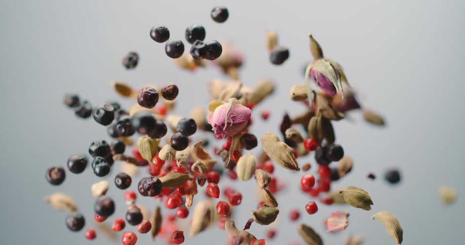 Colorful assortment of fruits and nuts jumping up and down on a white background