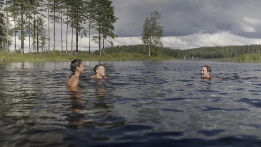People are swimming in a lake on a cloudy day