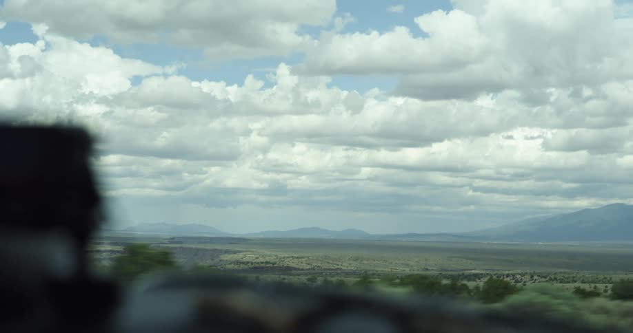 Cars speed by on the highway in an open landscape