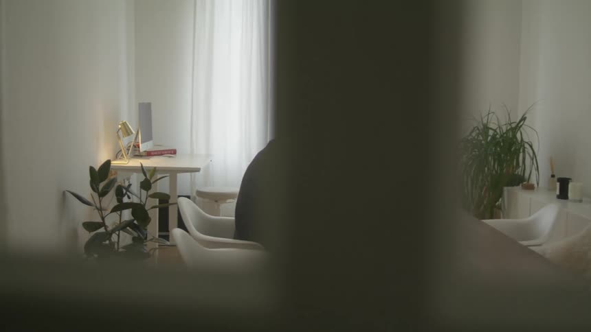 Man sits at table typing on laptop
