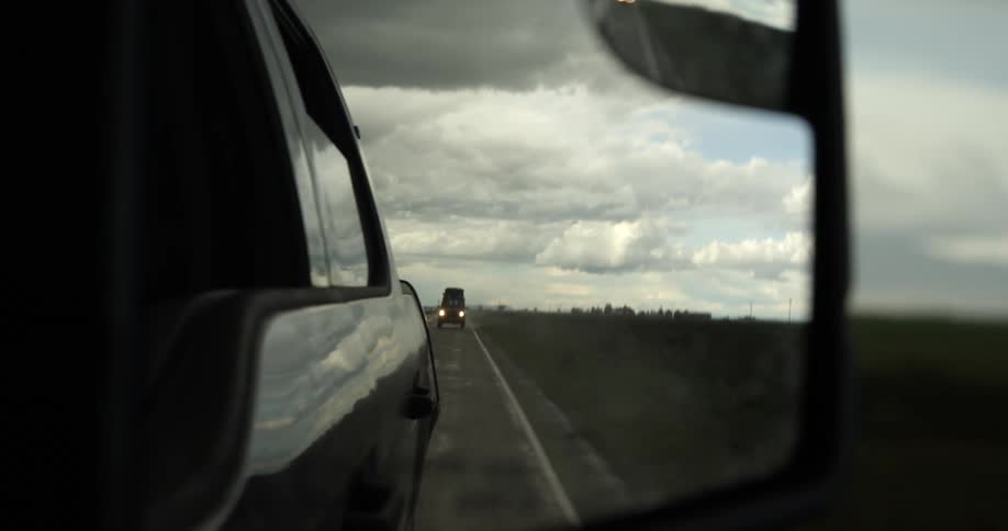 A view out of a side view mirror of a car