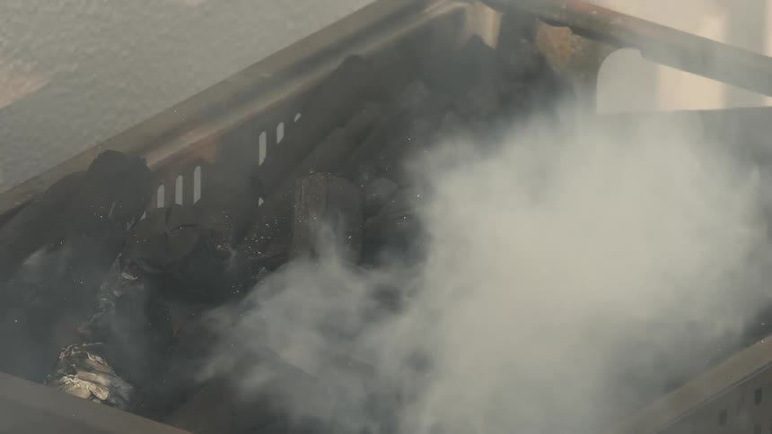 White smoke coming out of a bed of burning charcoal