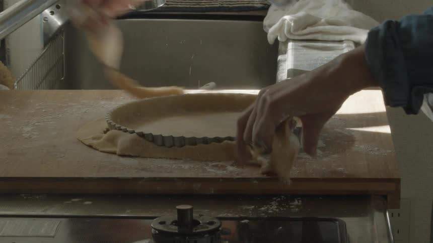 Preparing dough in a metal pie tray to bake a crust