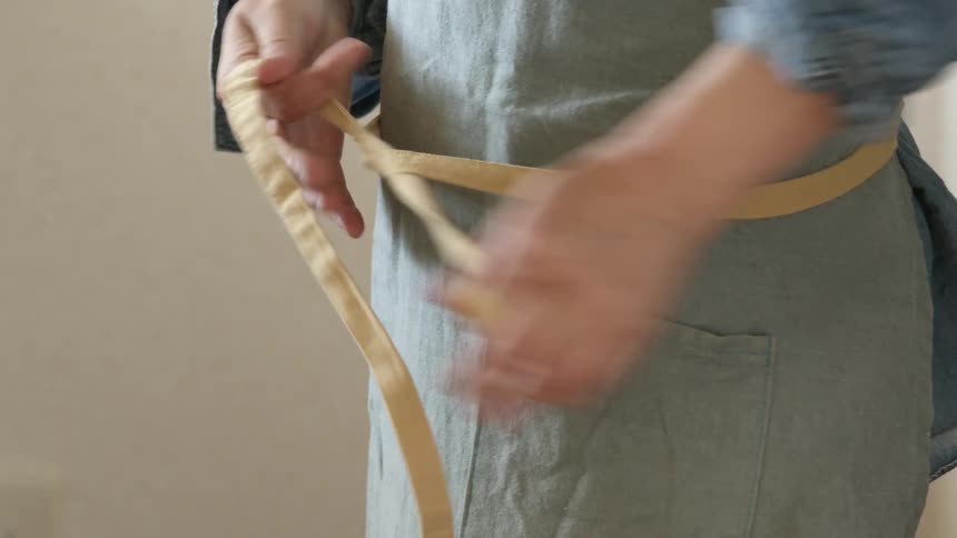 Person with blue shirt wears apron