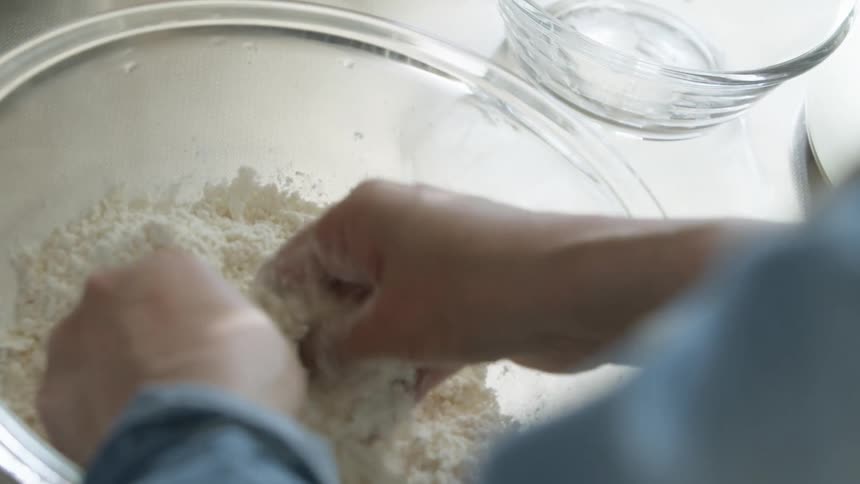 Mixing flour in a glass bowl by hand