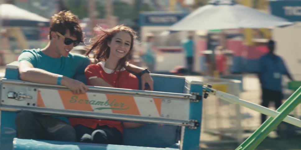 Young attractive pretty couple spends date riding carnival attractions in an amusement park