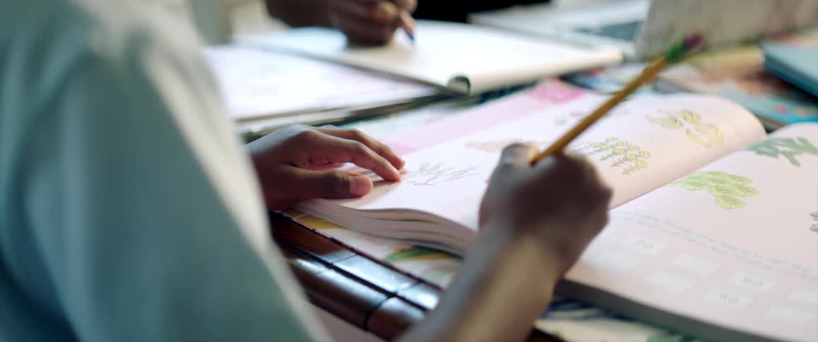 People sit at table doing homework