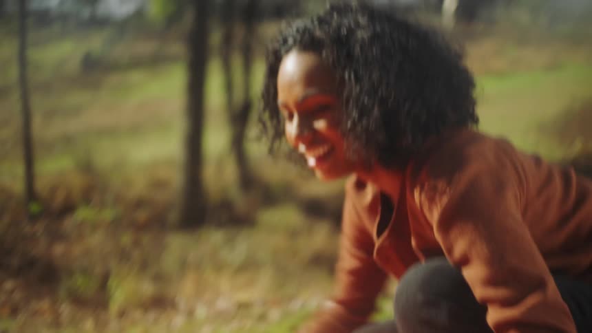 A woman flattens out a parachute in a field