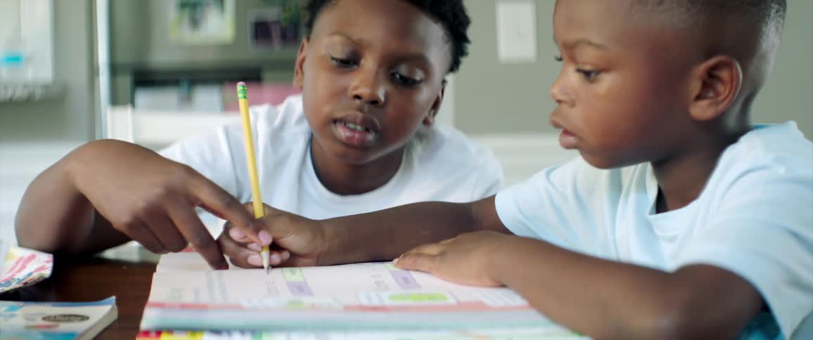 Young boys doing homework on the dinner table in the kitchen at home