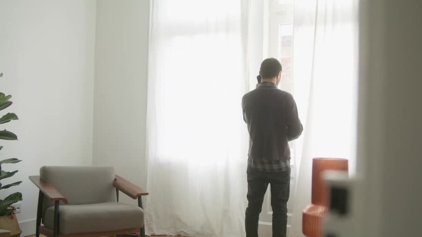 A man talks on his cell phone at home