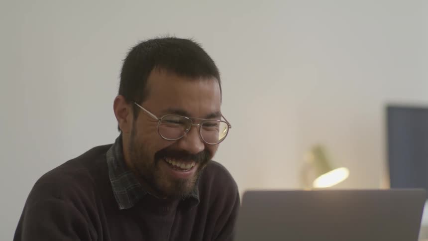 A man talking to someone on a laptop