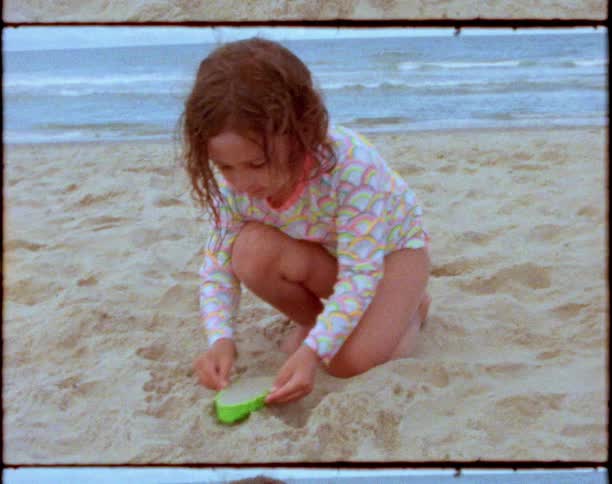 A child playing with sand on the beach