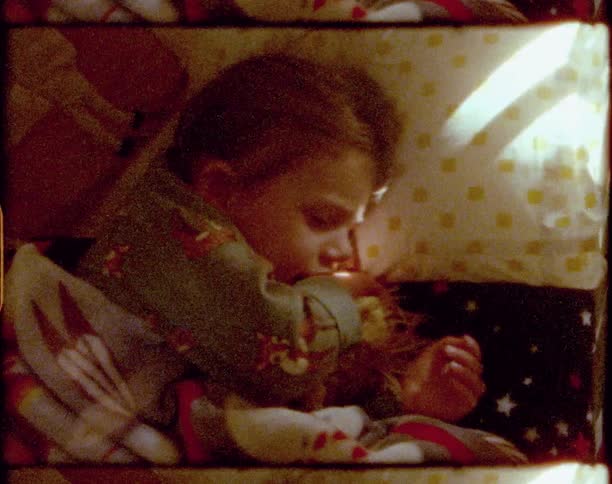Young girl lying in bed yawns and cuddles her pillow