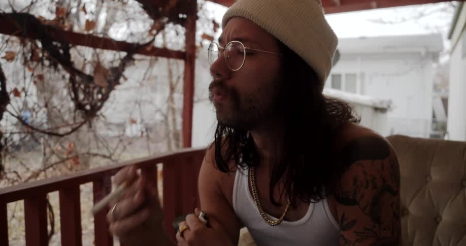 A man smoking sitting on a porch