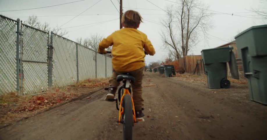 A child riding a bicycle down a road