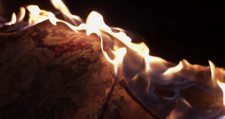 A couch on fire burning with flames and smoke