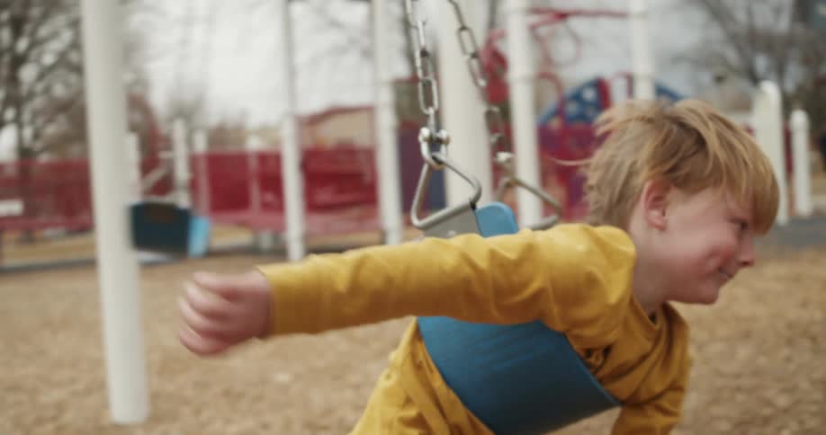 A child playing on a swing at a park