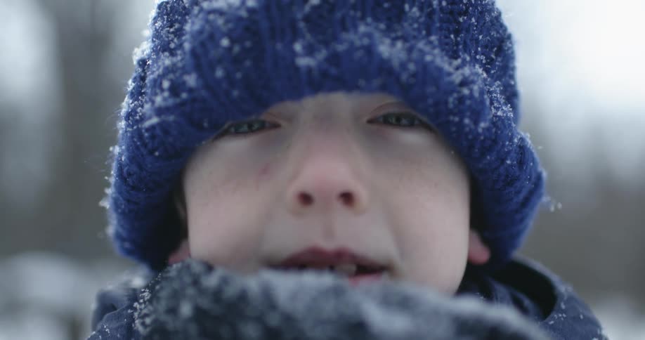 A child wearing a knit frost covered hat and scarf