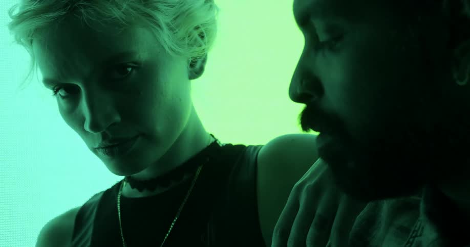 A man and woman standing in front of a light wall