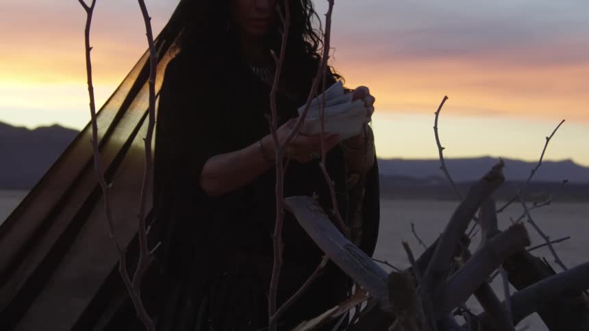 A woman putting paper on a pile of wood