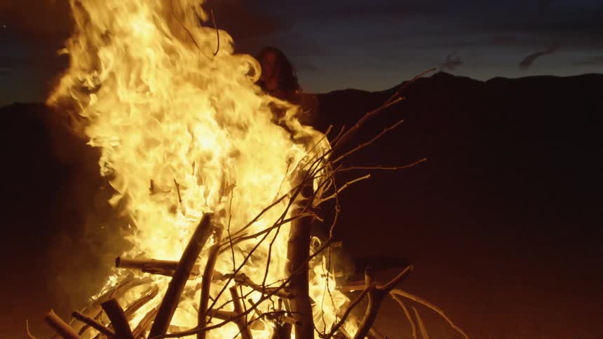 A bonfire burning in front of hills