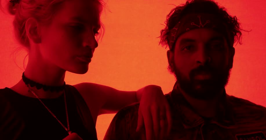 A man and a woman in a room with a big screen in the background