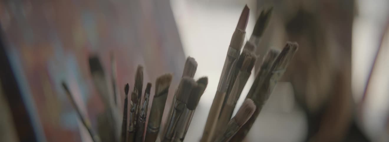 Many artist paintbrushes in a container