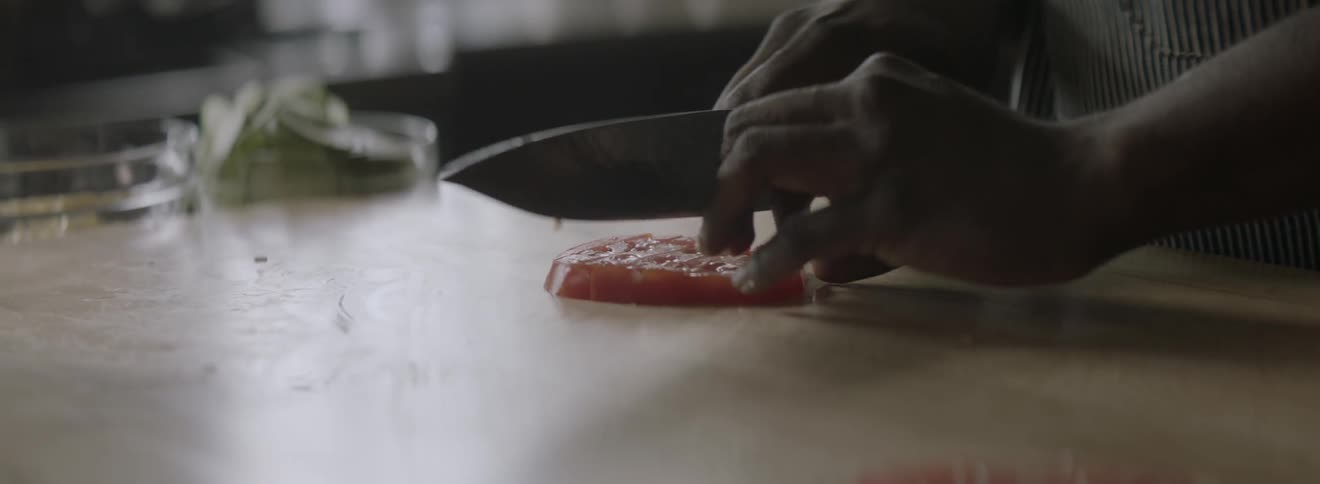 A person is cutting food on a board