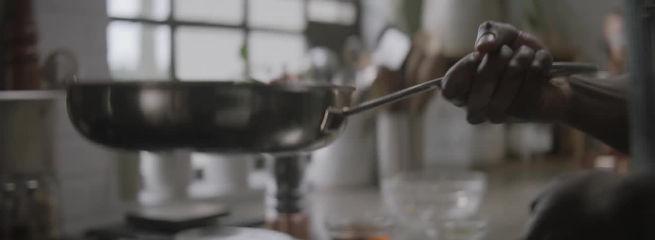 A person is flipping food in a skillet