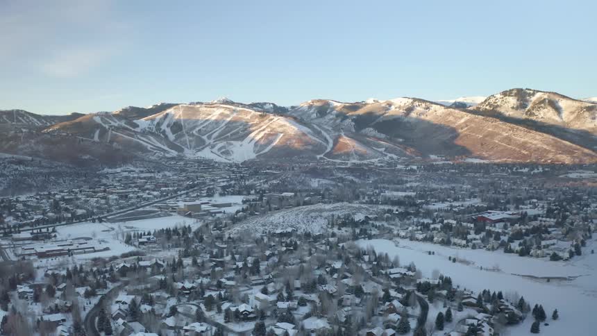 Snow covered community with mountains in the distance