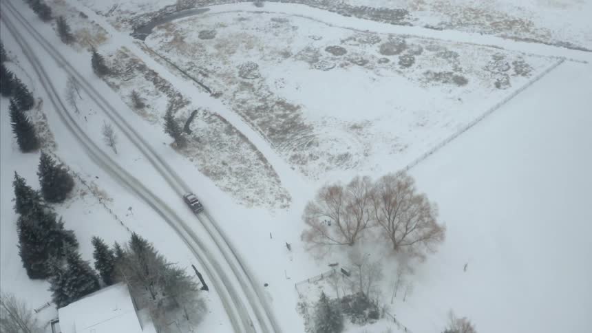 The vehicle drives on the snow covered road