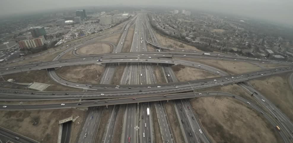 Vehicles traverse massive freeway intersection during the day