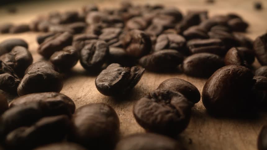 Coffee beans covering a wood surface