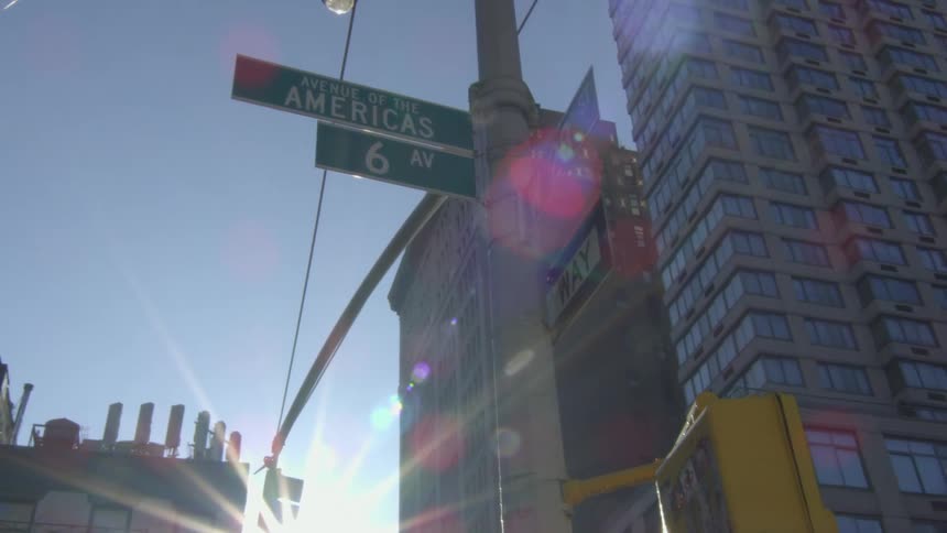 Street signs on the pole of a traffic sign in a metropolis during the day