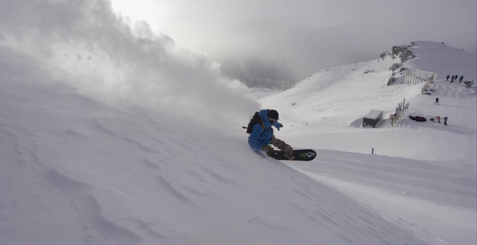 A man snowboards down a steep slope