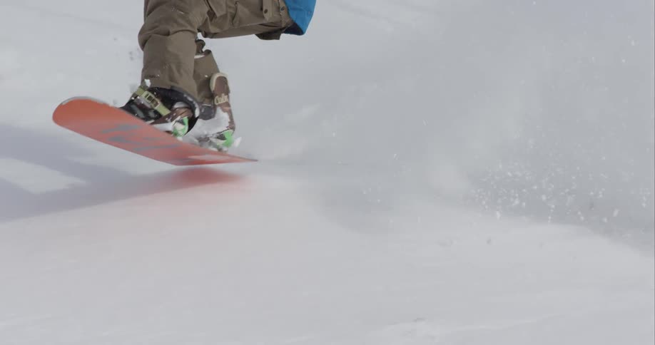A snowboarder rides down a mountainside