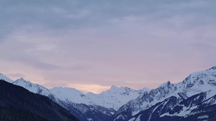 Snow covered peaks of a mountain range at evening