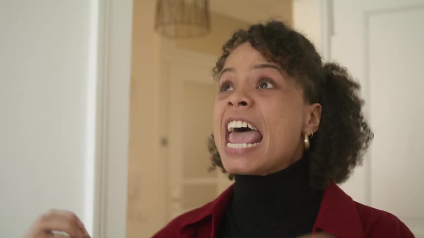A woman is standing in a room and screaming
