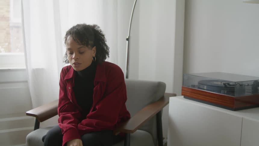 A woman squirms and shifts in her chair as she talks and listens