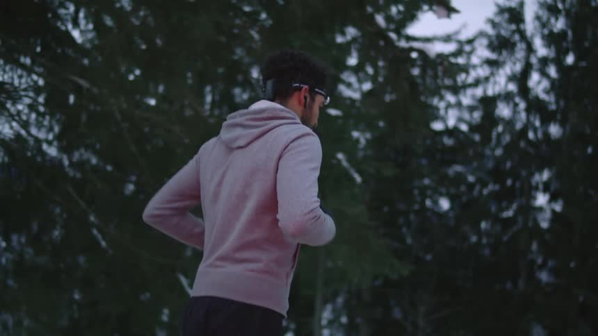 A man jogs along a mountain road on a cloudy evening