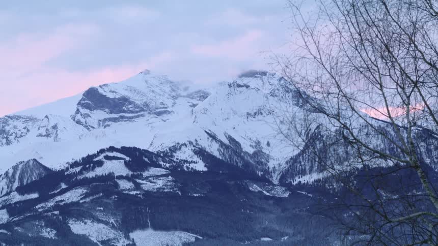 Snow covered mountain under a pink cloudy sky