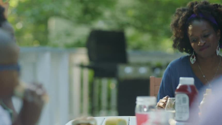 A woman a man a boy and a girl sitting around a table and eating