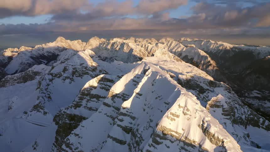 Clouds floating above a snowy mountain range in the wilderness